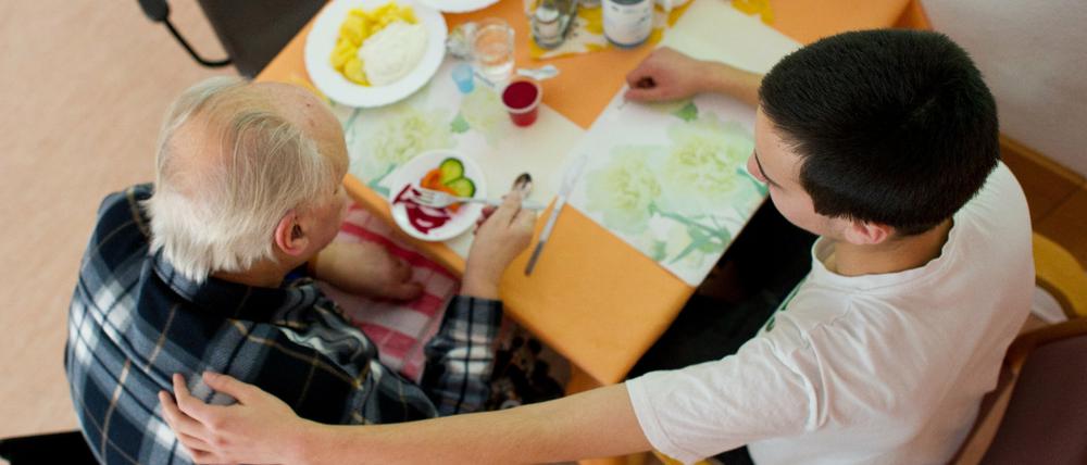Im AWO-Seniorenheim in Wildau betreut ein Freiwilliger im Rahmen seines Bundesfreiwilligendienstes einen alten Mann.