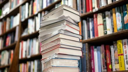 Ein Stapel Bücher liegt auf einem Verkaufstisch in einer Buchhandlung.