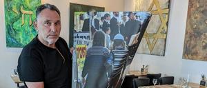 Der Künstler und sein Bild. Rafael Herlich zeigt das beschädigte Foto mit einer Szene aus Jerusalem.