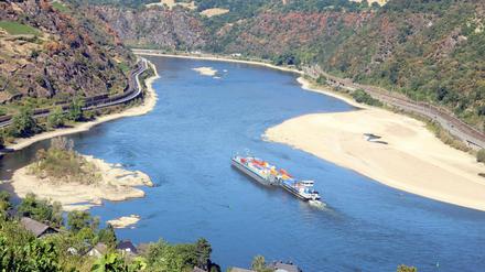 Ein Frachtschiff fährt auf dem Rhein an einer Sandbank vorbei (Symbolbild).