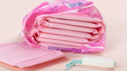 Damenbinden und ein Tampon liegen auf einem Tisch.