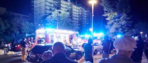 Evakuierte Bewohner eines Mietshauses stehen vor Feuerwägen in Gesundbrunnen. Auf dem Dach des eingerüsteten Hauses war ein Feuer ausgebrochen.