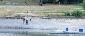 Polizisten stehen am Ufer des Badesees, an dem sich das Unglück ereignete.