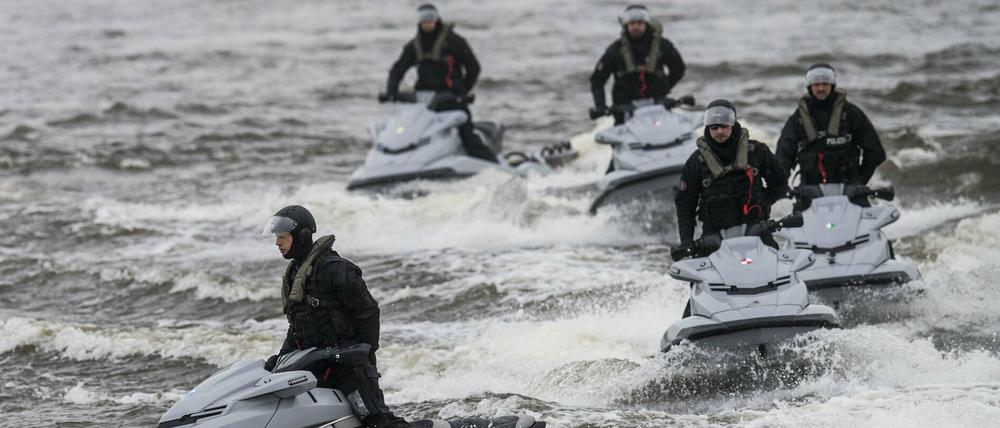 Hamburger Polizei auf Jetskis in aufgewühltem Wasser.