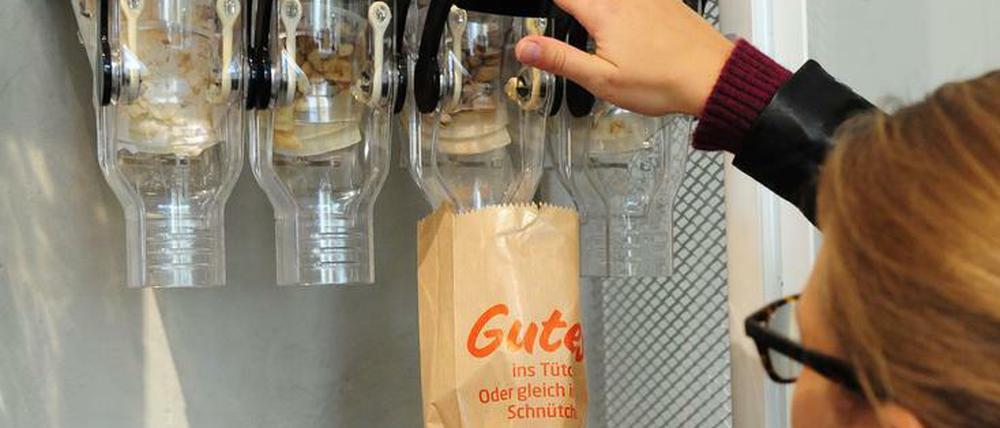 Eine Kundin füllt Lebensmittel in einem Unverpackt-Laden in eine Tüte.