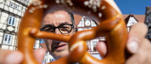 Bundesernährungsminister Cem Özdemir zeigt auf dem Marktplatz seines Geburtsorts eine Brezel. 