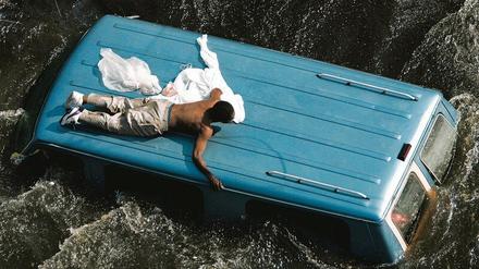 Warten auf Rettung. Ein Bewohner von New Orleans versucht, sich von Fluten nicht wegspülen zu lassen, die Hurrikan Katrina im September 2005 mit sich brachte.