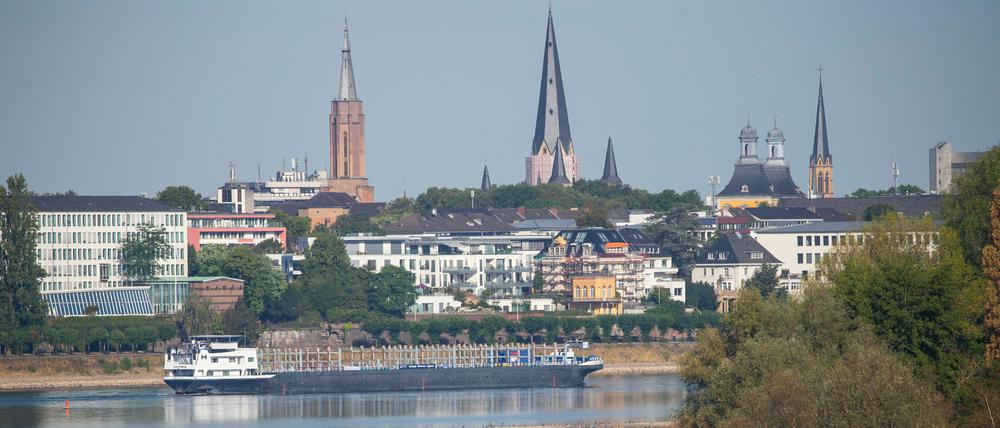 Ein Frachtschiff fährt auf dem Rhein, im Hintergrund ist das Stadtpanorama zu sehen. 