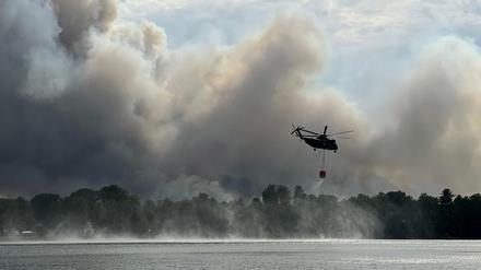 Ein Löschhubschrauber ist wegen des Waldbrandes bei Treuenbrietzen im Einsatz und hat Wasser am Seddiner See getankt. 