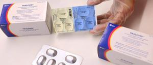 Auf einem Symbolbild werden Blister des Corona-Medikaments Paxlovid ausgepackt. 