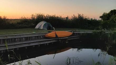 Schlafen am Wasser: Zelt und Boot im Hafen Linum.