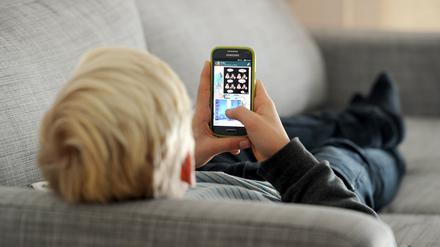 Ein Jugendlicher schaut auf sein Smartphone (Symbolbild).