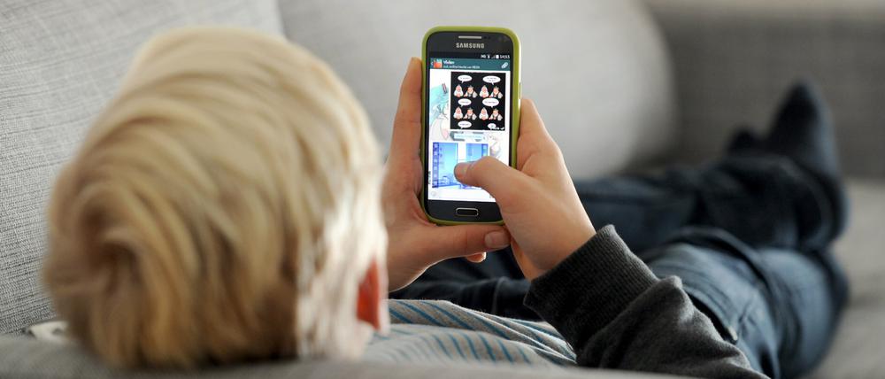 Ein Jugendlicher schaut auf sein Smartphone (Symbolbild).