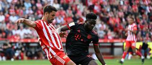 Alphonso Davies von Bayern München im Zweikampf mit Rani Khedira von Union.
