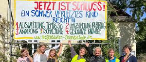 Eltern, Schüler:innen und Lehrende der Giesensdorfer Grundschule in Berlin mit einem Protestplakat für sichere Schulwege.