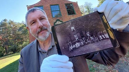 Bernd Küster, Vorsitzender des Fördervereins Jagdschloß, mit der vermutlich ältesten Darstellung einer Jagdgesellschaft vor dem Jagdschoß Stern auf einem Originalfoto von 1894.