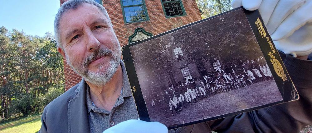 Bernd Küster, Vorsitzender des Fördervereins Jagdschloß, mit der vermutlich ältesten Darstellung einer Jagdgesellschaft vor dem Jagdschoß Stern auf einem Originalfoto von 1894.