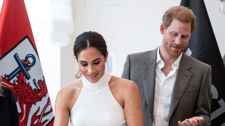 Prinz Harry und seine Frau Meghan tragen sich in das goldene Buch der Stadt ein. 