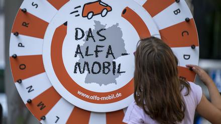 Ein Mädchen dreht am Glücksrad des „Alfa-Mobils“. 