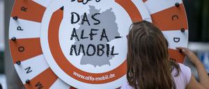 Ein Mädchen dreht am Glücksrad des „Alfa-Mobils“. 