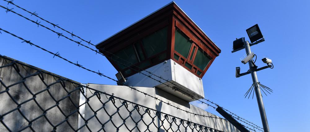 Sicherheitsleuchten und Überwachungskameras sind vor einem Gebäude auf dem Gelände der Justizvollzugsanstalt Tegel zu sehen.