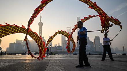 Wenn Papierdrachen zum Leben erwachen. Morgendämmerung am Bund entlang des Flusses Huanpu in Shanghai.