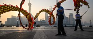 Wenn Papierdrachen zum Leben erwachen. Morgendämmerung am Bund entlang des Flusses Huanpu in Shanghai.