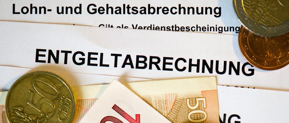 Euromünzen und Eurogeldscheine auf Lohn- und Gehaltsabrechnungen (Symbolbild).