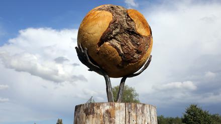 Die Welt in den Händen. An der B2 erinnert eine Skulptur an die Waldbrände.