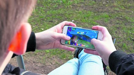 Ein Junge spielt auf einem Smartphone (Archivbild)