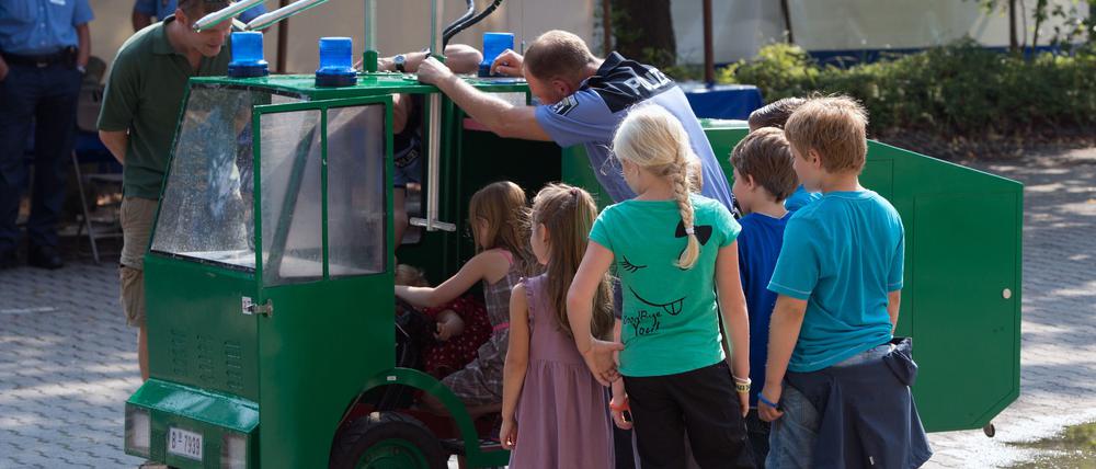 Kinder besichtigen die Ausbildungsstätte der Polizeidirektion 2 in Berlin während des Tages der offenen Tür bei der Berliner Polizei einen Spielzeug-Wasserwerfer. 