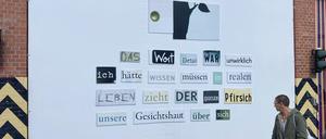 Eine Kollage aus ausgeschnittenen Wörtern von Herta Müller ist auf einem Werkstor auf dem Gelände der Uferhallen zu sehen.