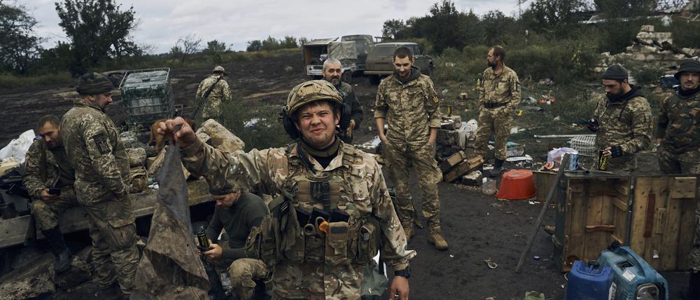 Ein ukrainischer Soldat hält in der Region Charkiw eine verschmutzte russische Flagge hoch.