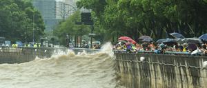 Menschen beobachten in Hangzhou eine Welle, die durch den Taifun ausgelöst wurde.