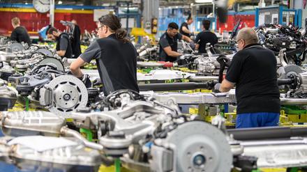 Montagemitarbeiter arbeiten in einem Werk in der Aggregateaufrüstung an Antriebssträngen