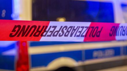  Symbolbild: Polizeiabsperrung mit Polizeiauto im Hintergrund. 