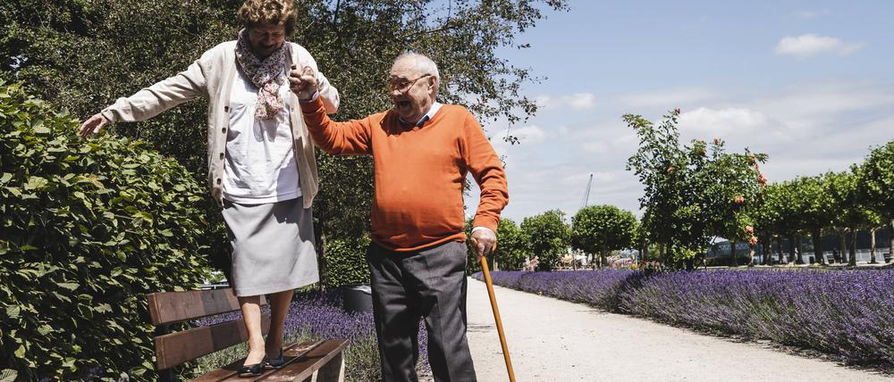 Senior couple having fun in the park, senior man helping womn to balance on bench model released Symbolfoto PUBLICATIONxINxGERxSUIxAUTxHUNxONLY UUF14943