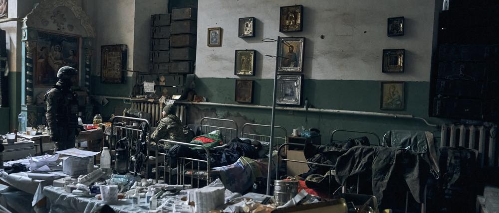 Ukrainische Soldaten inspizieren ein improvisiertes russisches Militärkrankenhaus in einer Kirche in Isjum, Region Charkiw, nach dem Rückzug russischer Truppen. 