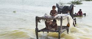 dpatopbilder - 03.09.2022, Pakistan, Sohbat Pur: Menschen sitzen in der südwestlichen pakistanischen Provinz Belutschistan auf Bettgestellen inmitten der Fluten. Die obdachlosen Menschen, die von den durch den Monsunregen ausgelösten verheerenden Überschwemmungen in Pakistan betroffen sind, erhalten angesichts der steigenden Zahl von Todesopfern und obdachlosen Familien im ganzen Land verstärkte internationale Aufmerksamkeit. Der Bundesplanungsminister appellierte an die internationale Gemeinschaft, für die 33 Millionen Menschen immense humanitäre Hilfe zu leisten. Foto: Zahid Hussain/AP/dpa +++ dpa-Bildfunk +++