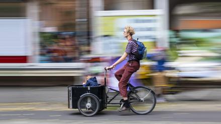 Vater mit Lastenrad und Kind in Berlin.