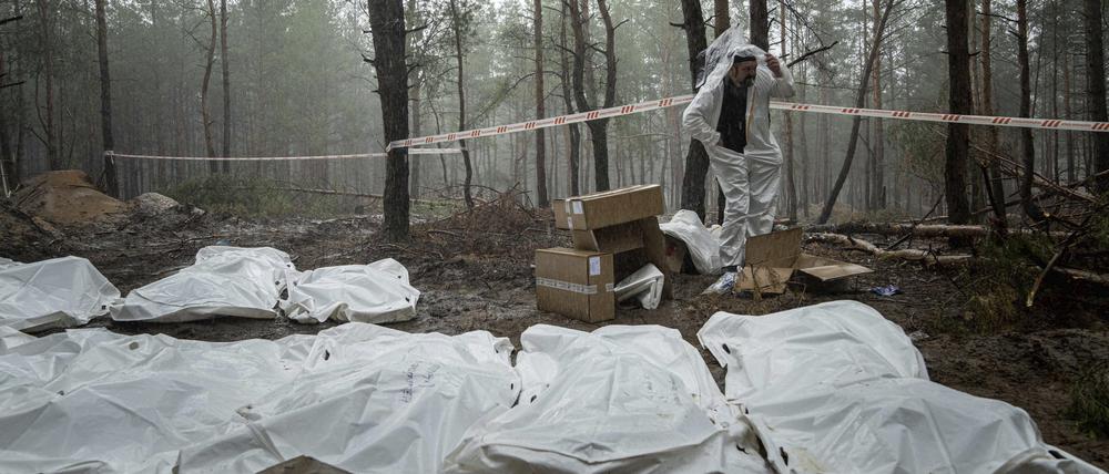 Säcke mit Leichen sind während der Exhumierung im kürzlich zurückeroberten Gebiet von Isjum, zu sehen.