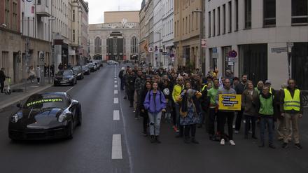 18.09.2022, Berlin: «Dienstwagen» steht auf einem Porsche 911 bei einer Protestaktion der Umweltschutz-Organisation Greenpeace vor der FDP-Bundeszentrale. Nach Informationen von Greenpeace kostet die Förderung eines Porsche 911 als Dienstwagen dem Staat so viel Geld wie der Zuschuss zu 50 Klimatickets für einen Jahrespreis von maximal 365 Euro. Um das Verhältnis bildhaft zu dokumentieren, hatte Greenpeace auf der gesperrten Reinhardtstraße auf einer Fahrspur den pkw platziert, auf der anderen Seite standen die Aktivisten. Foto: Paul Zinken/dpa +++ dpa-Bildfunk +++