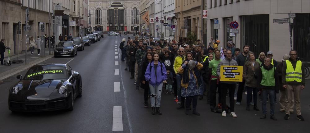 18.09.2022, Berlin: «Dienstwagen» steht auf einem Porsche 911 bei einer Protestaktion der Umweltschutz-Organisation Greenpeace vor der FDP-Bundeszentrale. Nach Informationen von Greenpeace kostet die Förderung eines Porsche 911 als Dienstwagen dem Staat so viel Geld wie der Zuschuss zu 50 Klimatickets für einen Jahrespreis von maximal 365 Euro. Um das Verhältnis bildhaft zu dokumentieren, hatte Greenpeace auf der gesperrten Reinhardtstraße auf einer Fahrspur den pkw platziert, auf der anderen Seite standen die Aktivisten. Foto: Paul Zinken/dpa +++ dpa-Bildfunk +++