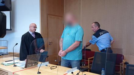 Ein 44-Jähriger in Handschellen steht am 19.09.2022 zu Prozessbeginn im Gerichtssaal am Landgericht Frankfurt/Oder. Dem Mann wird vorgeworfen, seine Frau vor den Augen der vier gemeinsamen Kinder erstochen zu haben. 