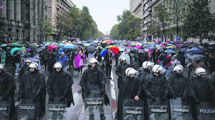 Police officers secure LGBT Activists during a pride march in front of the Constitutional Court in Belgrade, on September 17, 2022. - The situation was tense on September 17, 2022, in Belgrade where representatives of the LGBTQ community vowed to march despite a ban on a Europride march by the authorities, raising fears of potential unrest. (Photo by OLIVER BUNIC / AFP)
