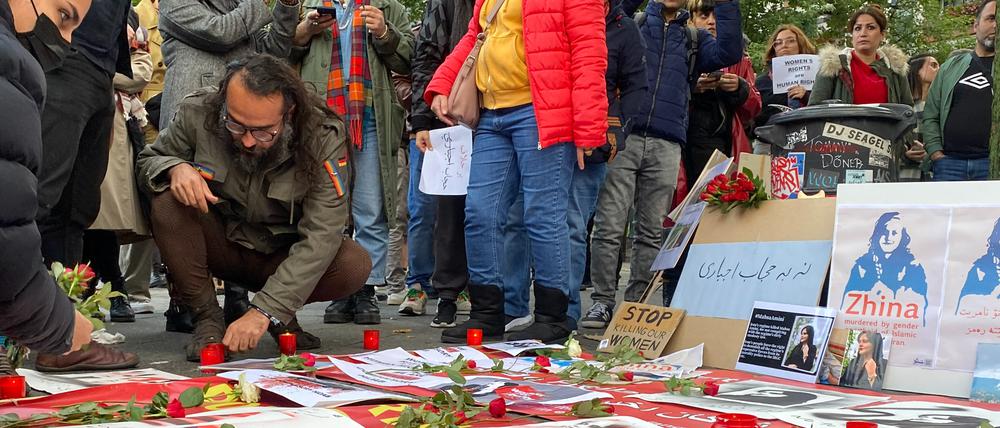 Nach der Kundgebung legen Teilnehmende in Gedanken an Jina Mahsa Amini Blumen nieder.