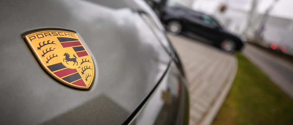 Das Porsche-Logo ist am Firmensitz in Stuttgart-Zuffenhausen auf einem Auto zu sehen.