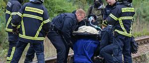 Polizisten versuchen, einen Klimaaktivisten im Rollstuhl von einer Gleisverbindung für den Transport von Braunkohle zum Kraftwerk Jänschwalde zu holen. 