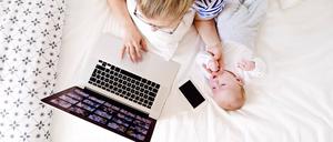 Eine Mutter mit betreut ein Kleinkind während der Arbeit. (Symbolbild)