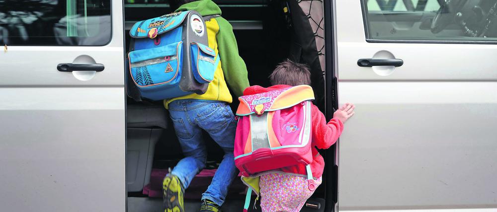 Brandenburg, Potsdam: Schulkinder steigen in ein privates Fahrzeug.